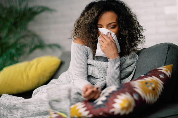 Sick female sitting on a couch 