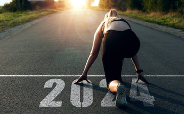 Lady getting ready to run. Year 2024 written on the paved ground