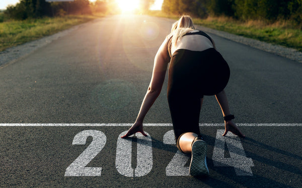 Lady getting ready to run. Year 2024 written on the paved ground