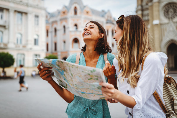 Women in larger city holding map and laughing 