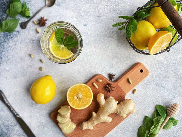 Countertop with lemongs and ginger on a cutting board and in bowls