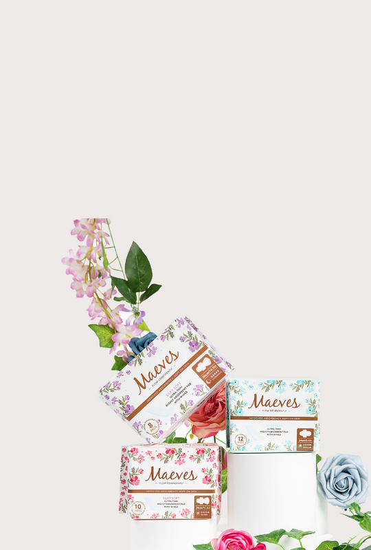 Boxes of Maeves Sanitary Pads with Flowers on the side and a light tan background